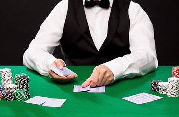 Image showing holdem dealer with playing cards and casino chips