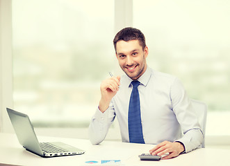 Image showing smiling businessman with laptop and documents