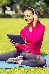 Image showing smiling woman with tablet pc outdoors