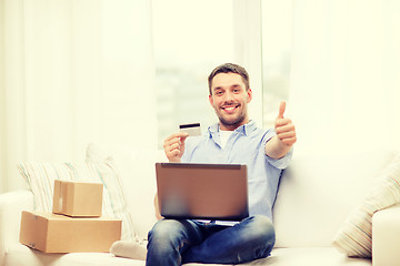 Image showing man with laptop, credit card and cardboard boxes