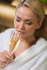 Image showing beautiful young woman drinking champagne at spa