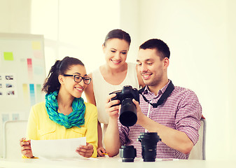 Image showing smiling team with photocamera working in office