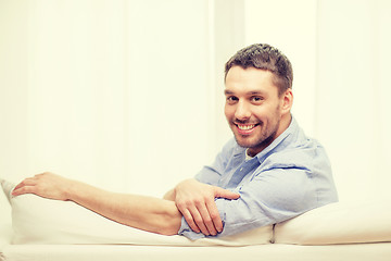 Image showing smiling man sitting on sofa at home