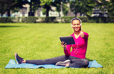 Image showing smiling woman with tablet pc outdoors