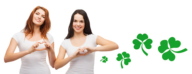 Image showing smiling girls showing heart gesture with shamrock