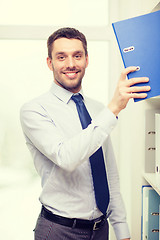 Image showing handsome businessman picking folder at office