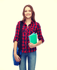 Image showing smiling female student with bag and notebooks