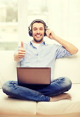 Image showing smiling man with laptop and headphones at home