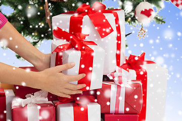 Image showing close up of woman with gifts and christmas tree