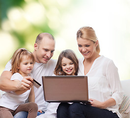 Image showing happy family with laptop computer and credit card