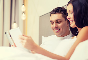 Image showing smiling couple in bed with tablet pc computers