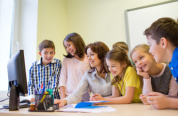 Image showing group of kids with teacher and computer at school