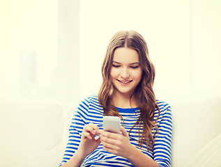 Image showing smiling teenage girl with smartphone at home