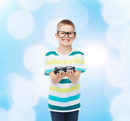 Image showing smiling boy in eyeglasses holding spectacles