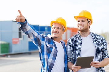 Image showing smiling builders in hardhats with tablet pc