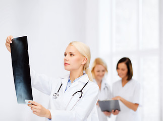 Image showing serious female doctor looking at x-ray