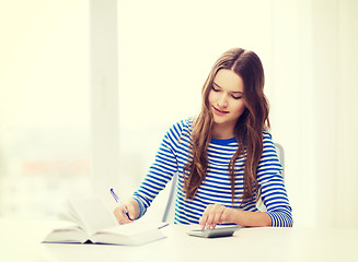 Image showing student girl with book, calculator and notebook