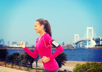 Image showing smiling young woman running outdoors