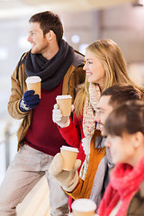 Image showing happy friends with coffee cups on skating rink