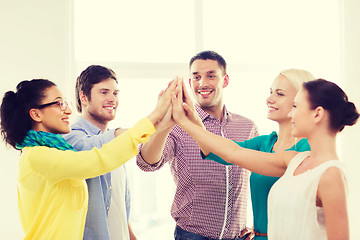 Image showing creative team doing high five gesture in office