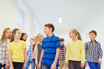 Image showing group of smiling school kids walking in corridor