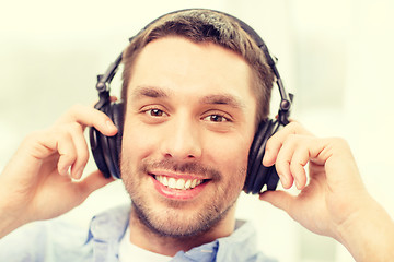 Image showing smiling young man in headphones at home