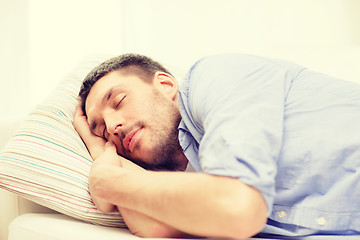 Image showing calm young man lying on sofa at home