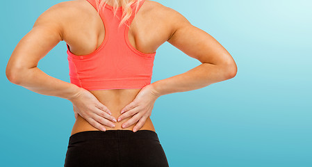 Image showing close up of sporty woman touching her back