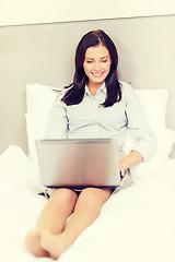 Image showing happy businesswoman with laptop in hotel room