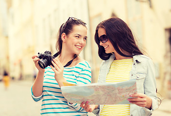 Image showing smiling teenage girls with map