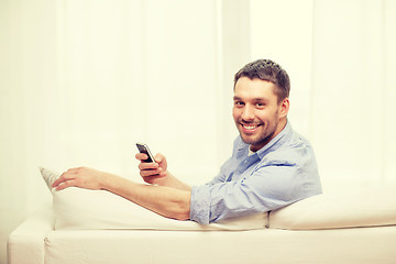 Image showing smiling man with smartphone at home