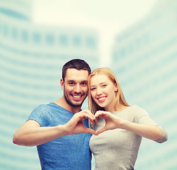 Image showing smiling couple showing heart with hands