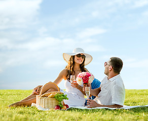 Image showing smiling couple drinking champagne on picnic