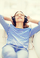 Image showing smiling young girl in headphones at home