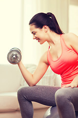 Image showing smiling girl exercising with dumbbells