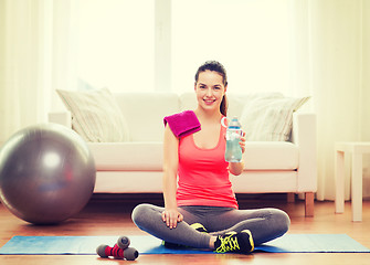 Image showing smiling girl with bottle of water after exercising