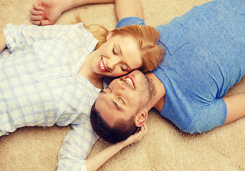 Image showing smiling happy couple lying on floor at home