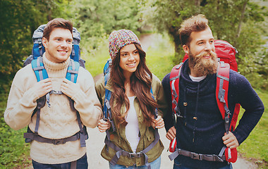 Image showing group of smiling friends with backpacks hiking