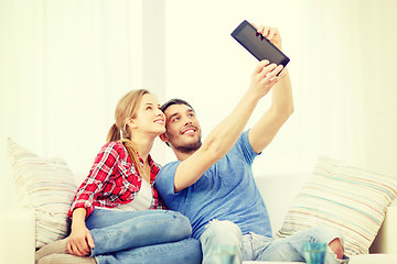 Image showing smiling couple with tablet pc computer at home