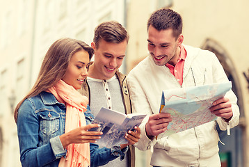 Image showing group of smiling friends with city guide and map