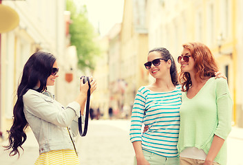 Image showing smiling teenage girls with camera