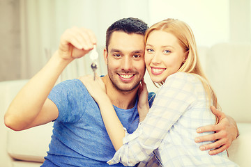 Image showing smiling couple holding keys at home