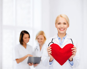 Image showing smiling female doctor with heart and stethoscope