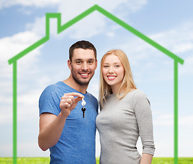 Image showing smiling couple holding key over green house