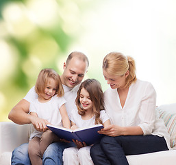 Image showing happy family with book at home