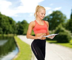 Image showing smiling sporty woman with tablet pc computer