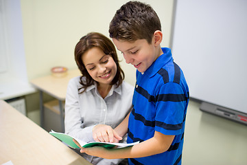 Image showing school boy with notebook and teacher in classroom