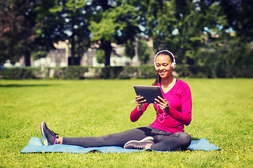 Image showing smiling woman with tablet pc outdoors