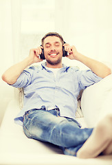 Image showing smiling young man in headphones at home