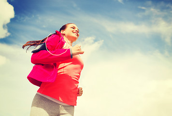 Image showing smiling young woman running outdoors